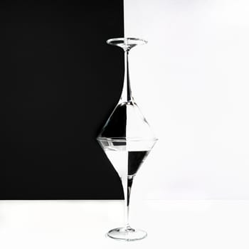 two glasses superimposed on a white surface and a two-tone background