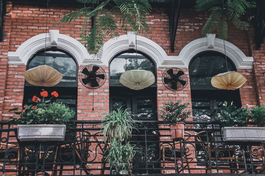 Rustic building balcony decorated with houseplants creating a calm and relaxing living space in the historical Old Quarter or french Quarter in Hanoi City