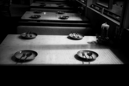 Empty plate at a closed up restaurant shows the loneliness, economic crisis and depression brought about by social distancing, lock down and self isolation due to the covid-19 pandemic