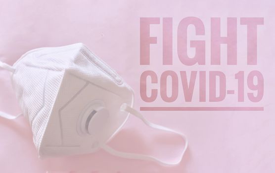 N95 mask against a pink background with the words Fight Covid-19 written on it to raise awareness in fighting the coronavirus global pandemic crisis