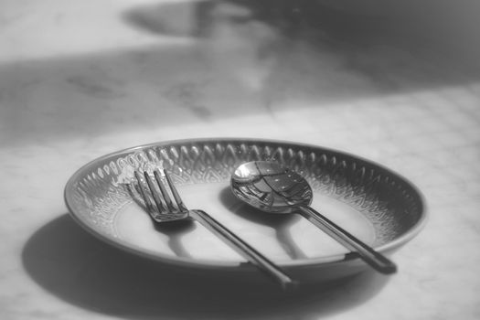 Empty plate at a closed up restaurant shows the loneliness, economic crisis and depression brought about by social distancing, lock down and self isolation due to the covid-19 pandemic