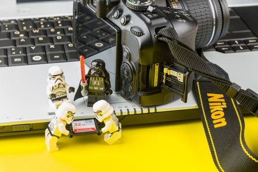 Bangkok, Thailand - March, 31, 2020 : Lego star wars stormtrooper inserting the sd card into the notebook sd card reader.