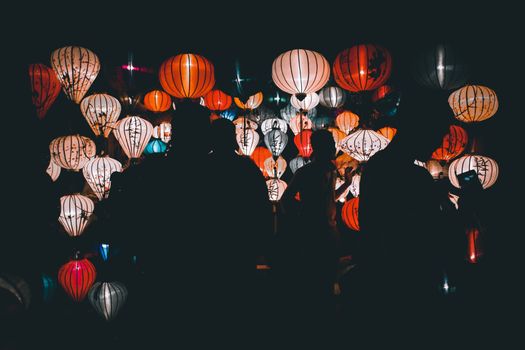 Silhouettes of people looking at the famous lanterns of Hoi an City during the Lantern Festival