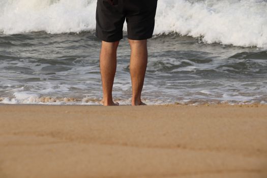 Low section of a man walking on the beach