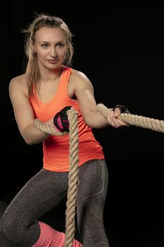 athletic girl exercising with a thick rope