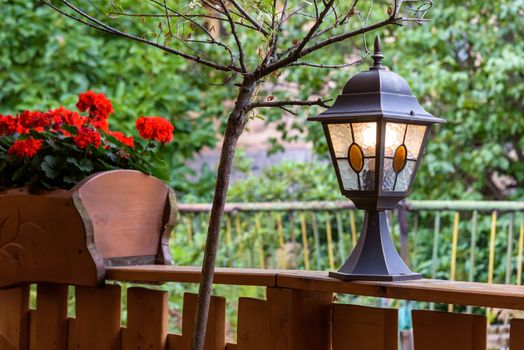 Shining lamp in a garden as a background