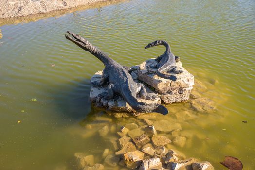 Dinosaurs statues on the pond in Geosfera park in Jaworzno, Poland