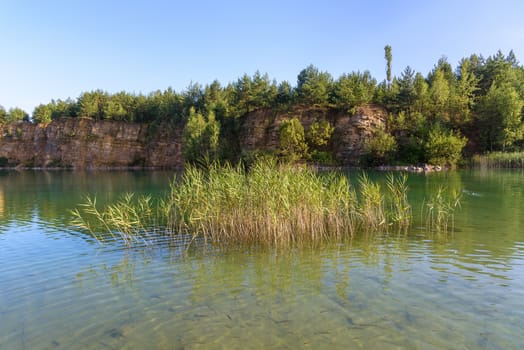 Sandstone cliffs by the pond in an old quarry in Grodek park in Jaworzno, Poland