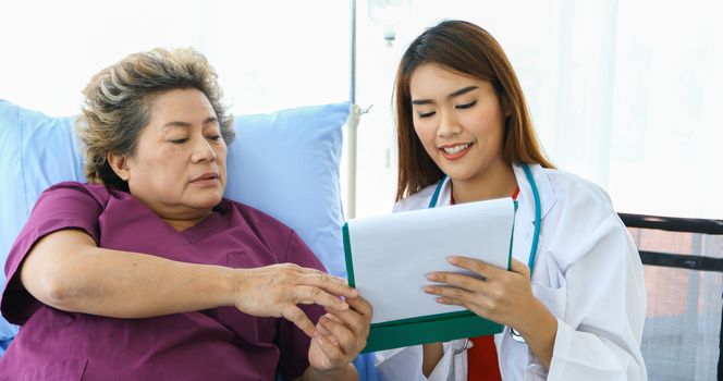 Doctor meeting and explaining medication to old woman patient at Hospitals