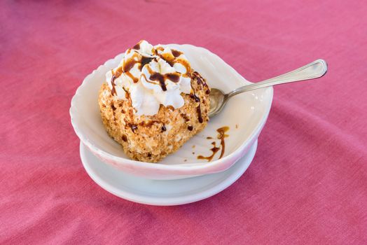 Italian ice cream dessert with topping and whipped cream on the pink tablecloth