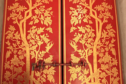 Traditional Chinese motifs on Chinese wooden doors in the Emerald Buddha housed, wat Phra Kaew Temple Bangkok, Thailand