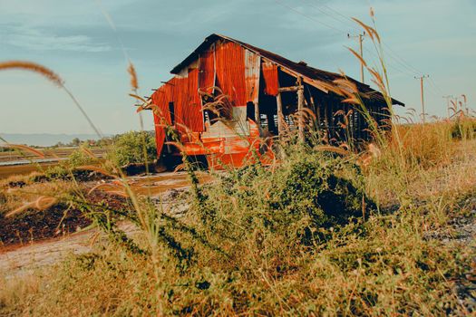 Rusty tin barn house in the countryside of Kampot that is used to store harvested salt from the saltfields, shows the authentic lifestyle, livelihood and local culture of the Cambodian people