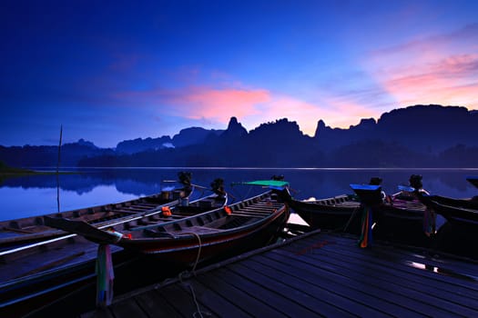 Tropical lakeside hut and wooden boat in Khao Sok national park, Cheow Lan Lake or Ratchaprapha Dam Surat Thani, Thailand
