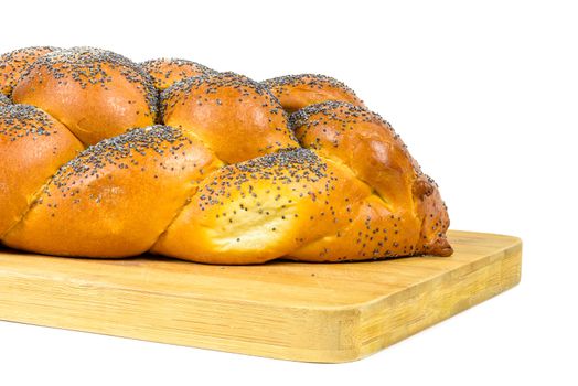 Closeup of fresh whole challah bread on chopping board isolated on white background with clipping path