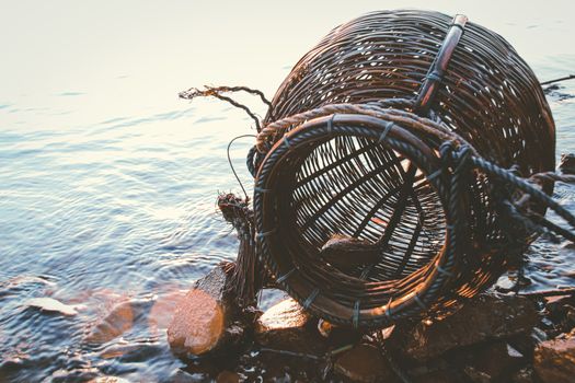Woven rattan creel or fishing basket that is a traditional fish container in rural fishing village in Cambodia that shows authentic life and local culture