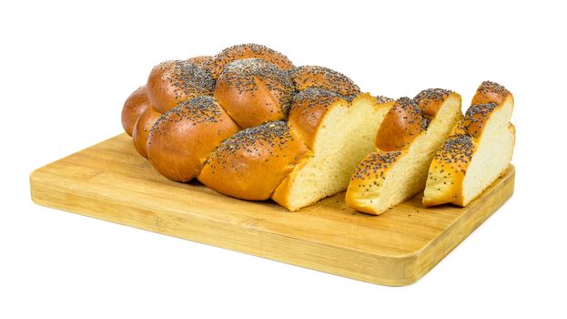 Fresh sliced challah bread on chopping board isolated on white background with clipping path