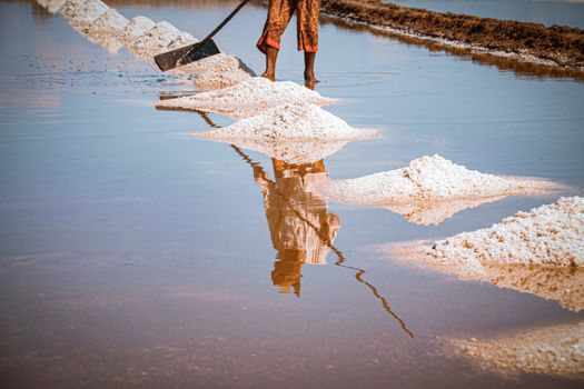 Cinematic photo of saltfield worker harvesting salt in Kampot Province in Cambodia that shows the local culture, livelihood and real life of the Khmer people