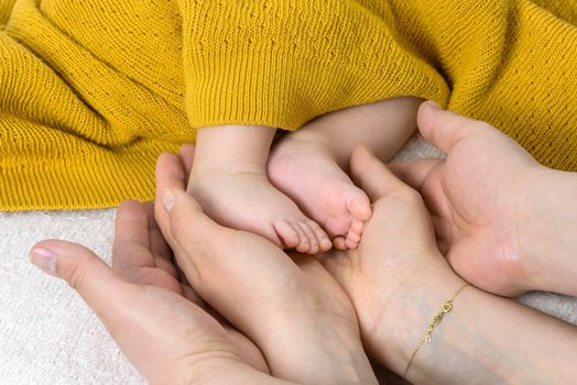 Closeup of newborn baby feet in parent hands