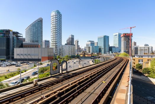 The railway tracks of Docklands Light Railway with Canary Wharf skyscrapers in the background.