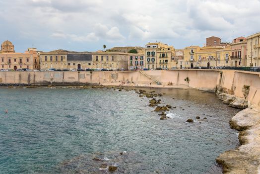 Waterfront with small pebble beach on Ortygia Island in Syracuse, Sicily, Italy