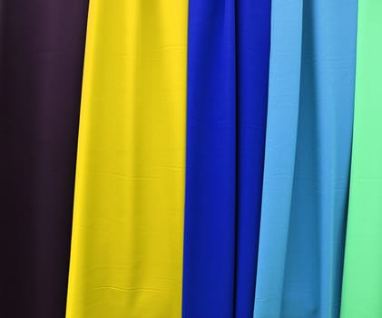 Detailed close up view on samples of cloth and fabrics in different colors found at a fabrics market.