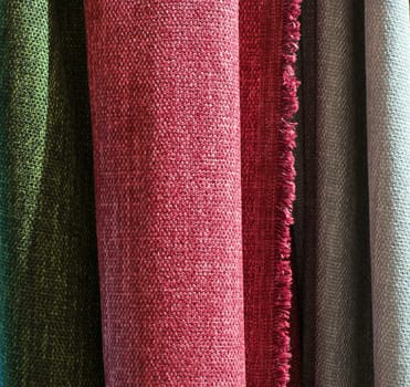 Detailed close up view on samples of cloth and fabrics in different colors found at a fabrics market.