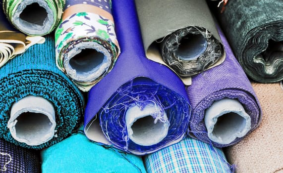 Detailed close up view on samples of cloth and fabrics in different colors found at a fabrics market.