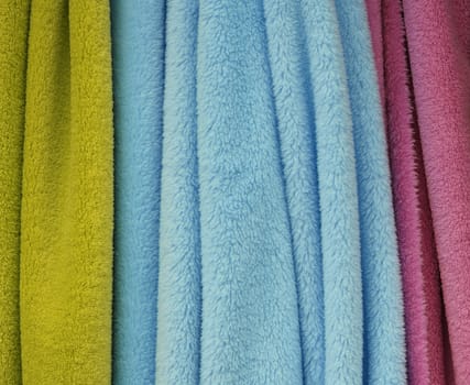 Detailed close up view on samples of cloth and fabrics in different colors found at a fabrics market.