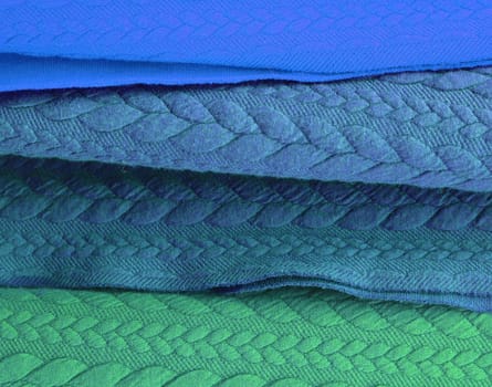 Detailed close up view on samples of cloth and fabrics in different colors found at a fabrics market.