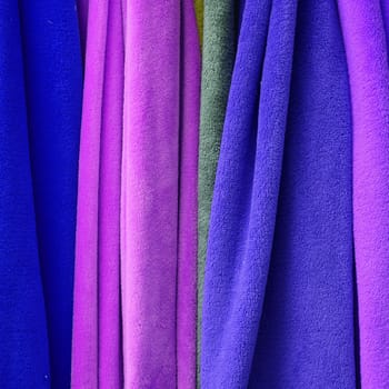 Detailed close up view on samples of cloth and fabrics in different colors found at a fabrics market.