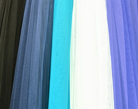 Detailed close up view on samples of cloth and fabrics in different colors found at a fabrics market.