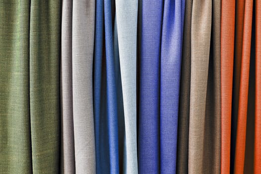 Detailed close up view on samples of cloth and fabrics in different colors found at a fabrics market.