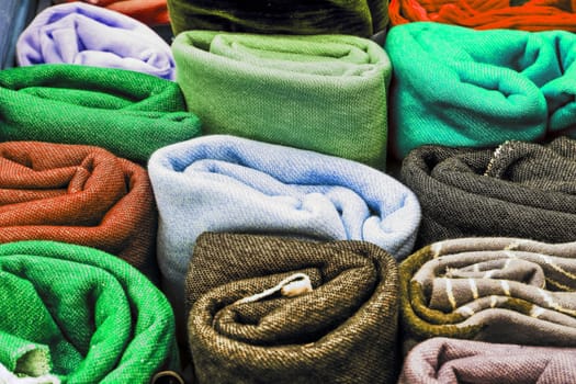 Detailed close up view on samples of cloth and fabrics in different colors found at a fabrics market.