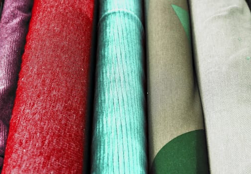 Detailed close up view on samples of cloth and fabrics in different colors found at a fabrics market.