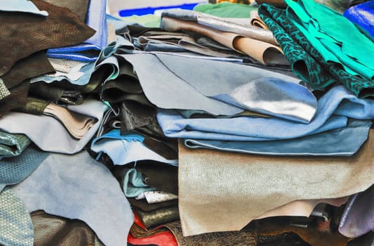 Detailed close up view on samples of cloth and fabrics in different colors found at a fabrics market.