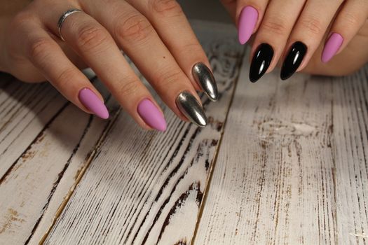 Hands with long artificial manicured nails colored with red nail polish