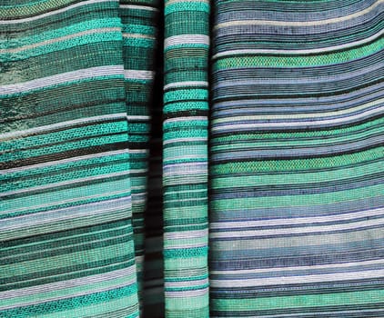 Detailed close up view on samples of cloth and fabrics in different colors found at a fabrics market.