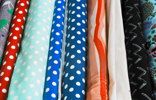 Detailed close up view on samples of cloth and fabrics in different colors found at a fabrics market.