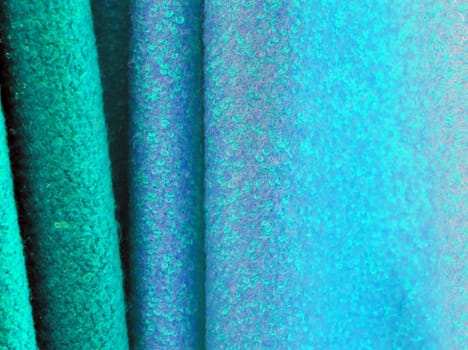 Detailed close up view on samples of cloth and fabrics in different colors found at a fabrics market.