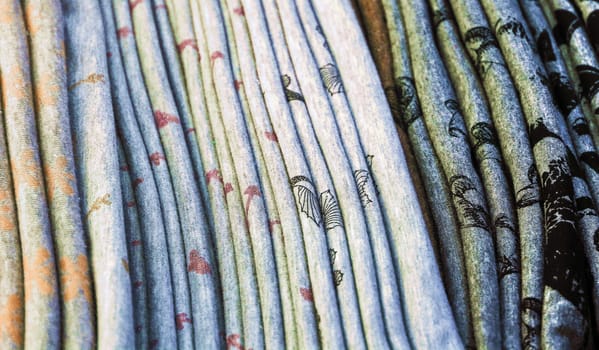 Detailed close up view on samples of cloth and fabrics in different colors found at a fabrics market.