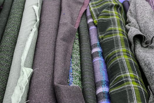 Detailed close up view on samples of cloth and fabrics in different colors found at a fabrics market.