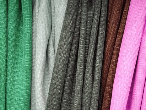 Detailed close up view on samples of cloth and fabrics in different colors found at a fabrics market.