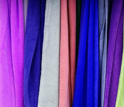 Detailed close up view on samples of cloth and fabrics in different colors found at a fabrics market.