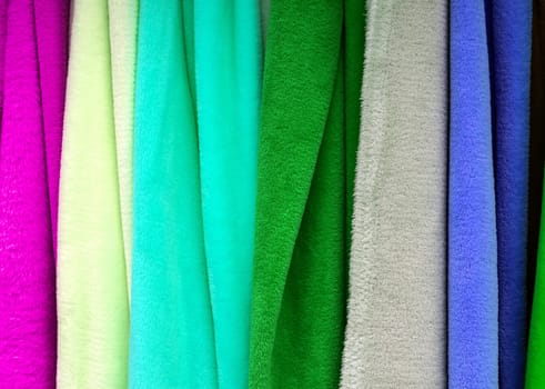 Detailed close up view on samples of cloth and fabrics in different colors found at a fabrics market.