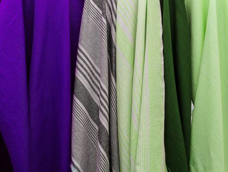 Detailed close up view on samples of cloth and fabrics in different colors found at a fabrics market.