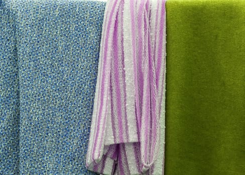 Detailed close up view on samples of cloth and fabrics in different colors found at a fabrics market.