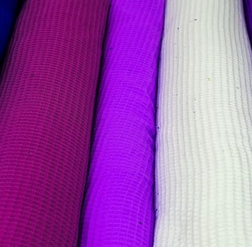 Detailed close up view on samples of cloth and fabrics in different colors found at a fabrics market.