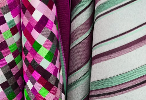 Detailed close up view on samples of cloth and fabrics in different colors found at a fabrics market.