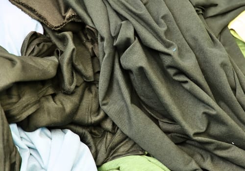 Detailed close up view on samples of cloth and fabrics in different colors found at a fabrics market.