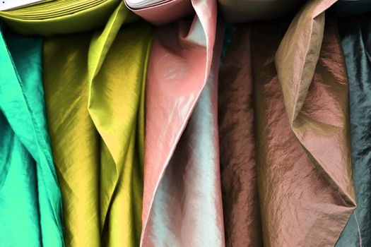 Detailed close up view on samples of cloth and fabrics in different colors found at a fabrics market.